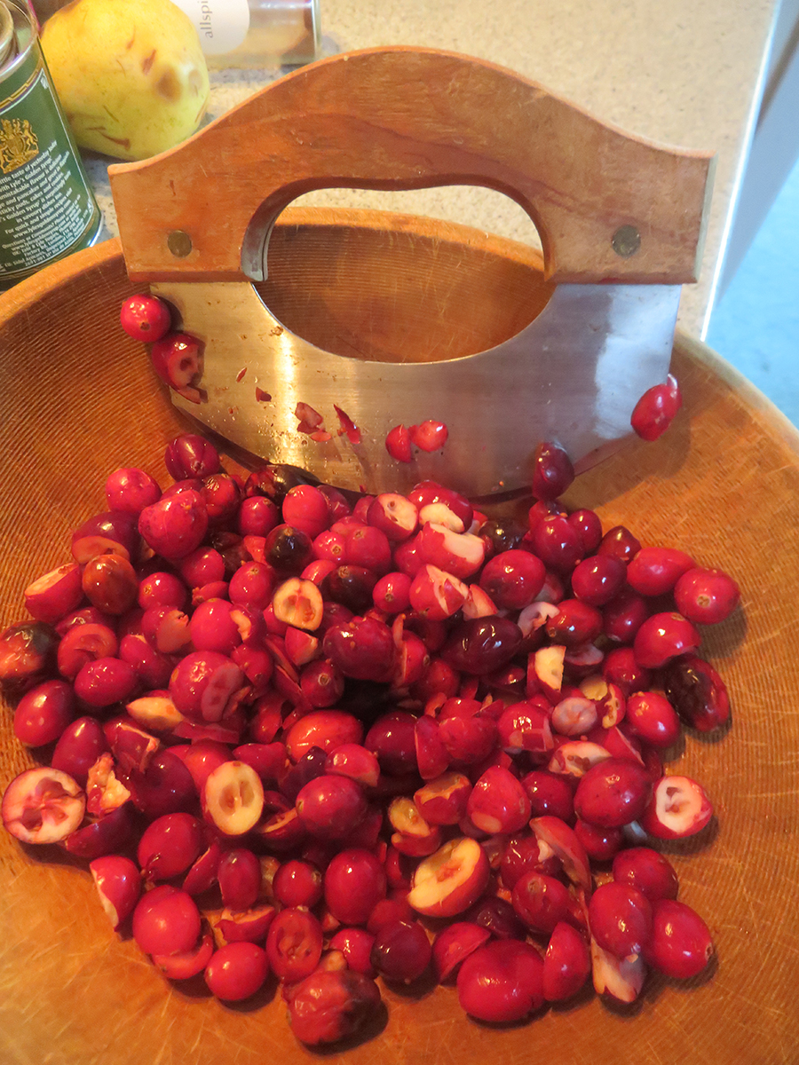 Chopping Cranberries in a wooden bowl 
